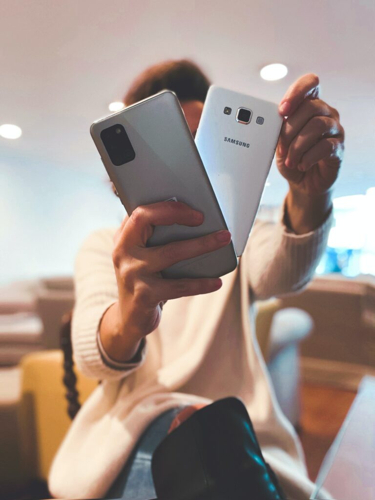A woman holds two samsung smart phones in her hands